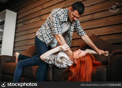 Man strangles woman with a tie, quarrel, stress, family conflict, domestic violence. Problem relationship. Man strangles woman with a tie, domestic violence
