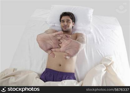 Man stretching his arms in bed