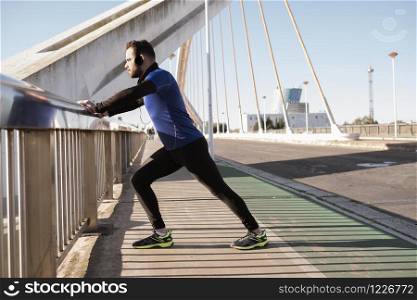 man stretching on a bridge railing. sport concept