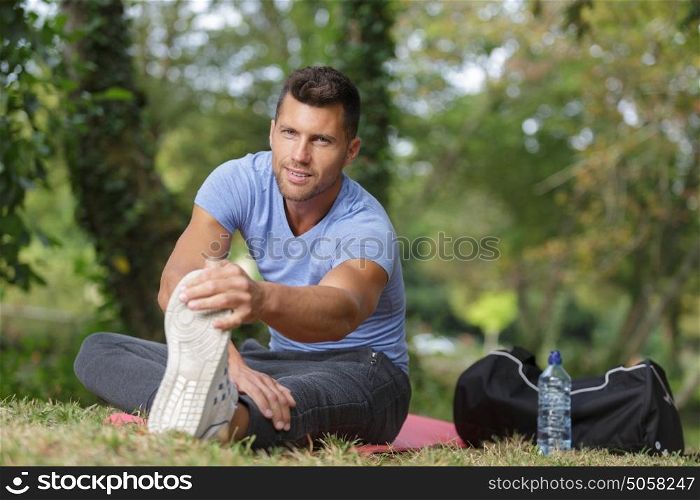 man stretching out muscles in park