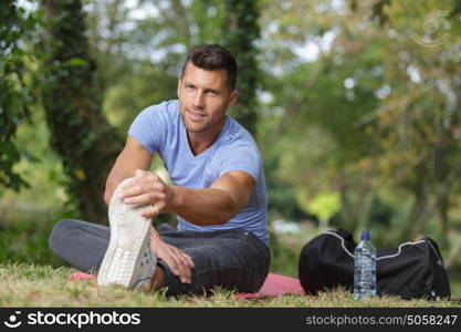 man stretching out muscles in park