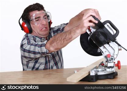 Man struggling to use a mitre saw