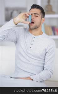 man suffering from asthma on the living room sofa