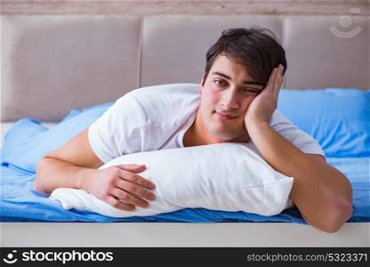 Man suffering from insomnia lying in bed