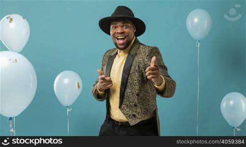man suit sunglasses party with balloons pointing