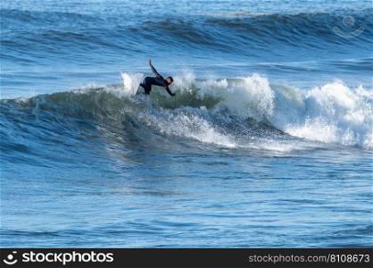 Man surfing atlantic ocean waves, Furadouro Beach, Ovar,Aveiro, Portugal