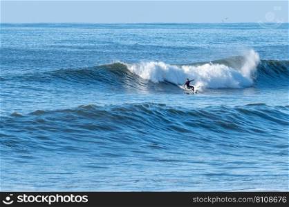 Man surfing atlantic ocean waves, Furadouro Beach, Ovar,Aveiro, Portugal