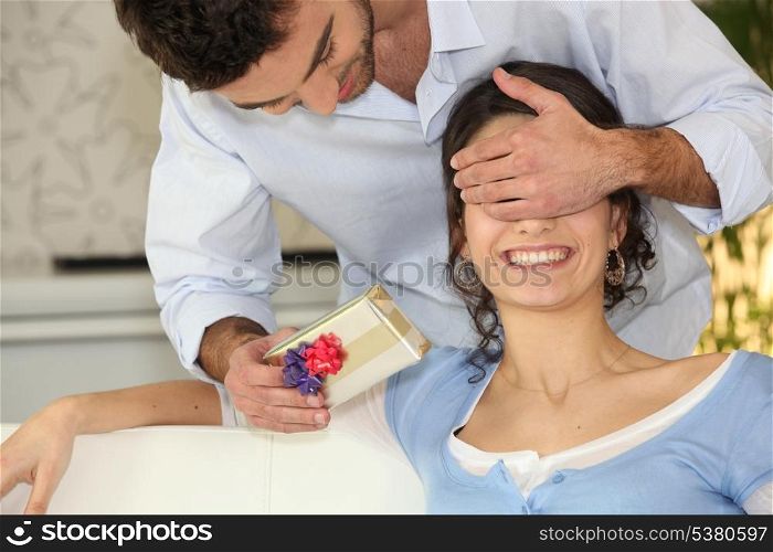 Man surprising woman with gift