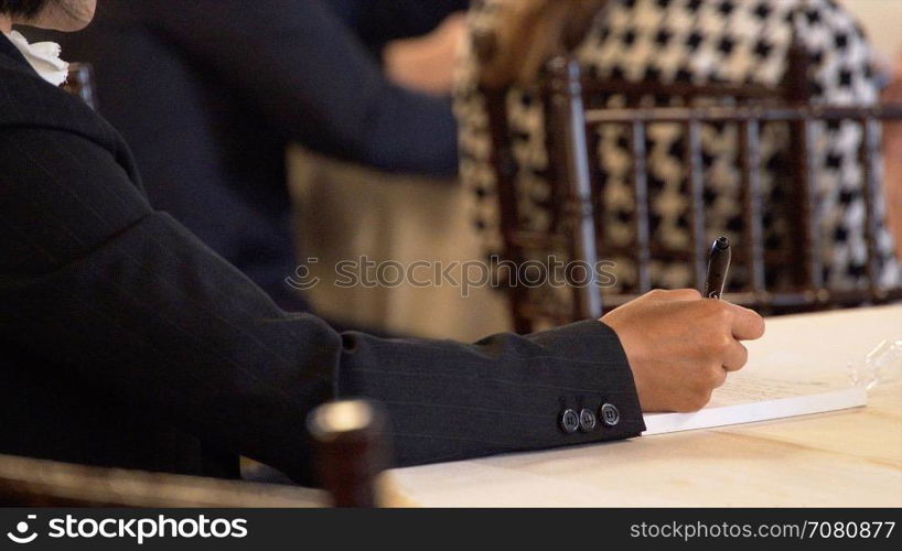 Man takes notes at a conference lecture