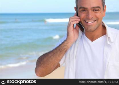 Man taking a call whilst at the beach