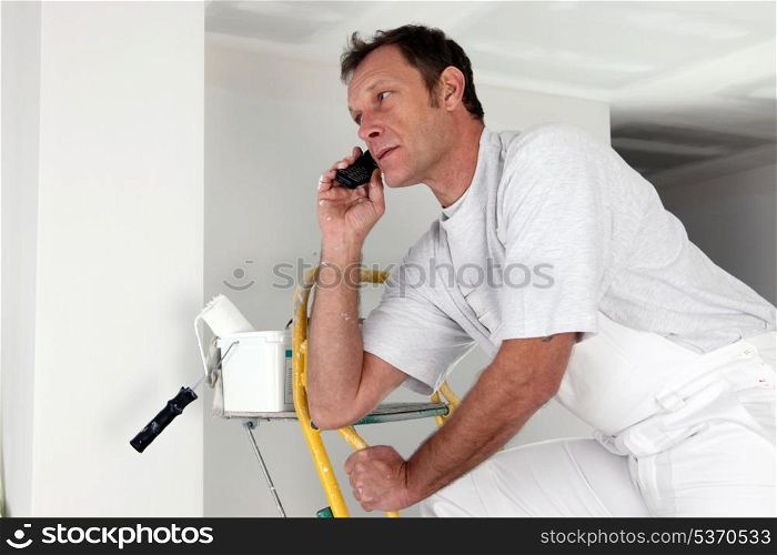 Man taking a phone call whilst painting