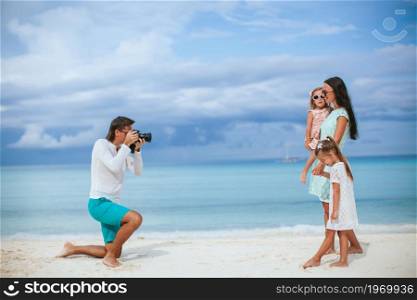Man taking a photo of his family on the beach. Man taking a photo of his family