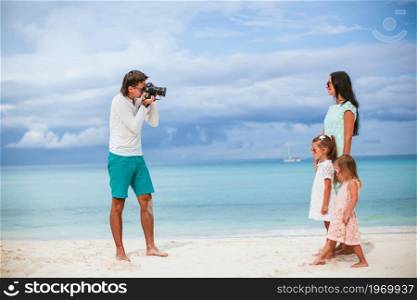 Man taking a photo of his family on the beach. Man taking a photo of his family
