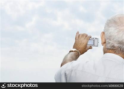 Man taking a picture of the sky