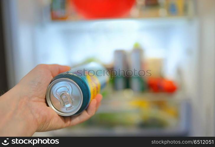 Man taking beer can from fridge. Man taking beer from fridge