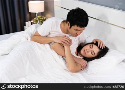 man taking care of his sick wife on a bed at home