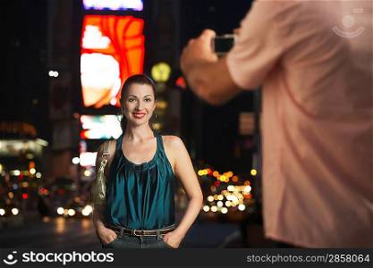 Man Taking Photo of Woman in Times Square
