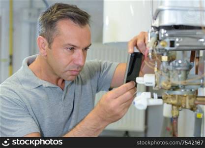 man taking picture of a boiler