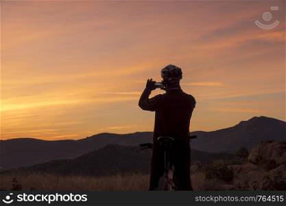 Man taking sunset sky picture on the mountain at sunset