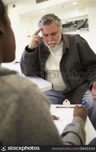 Man Talking To Counsellor Who Takes Notes