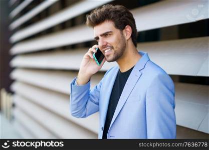 Man talking to his smartphone with a happy expression outdoors. Man talking to his smartphone with a happy expression