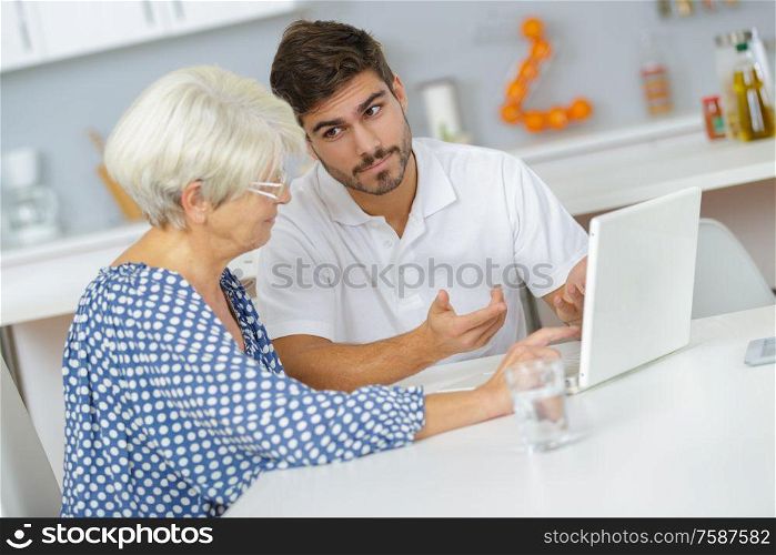 man teaching his granny to use the laptop