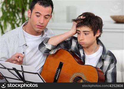 Man teaching son the guitar
