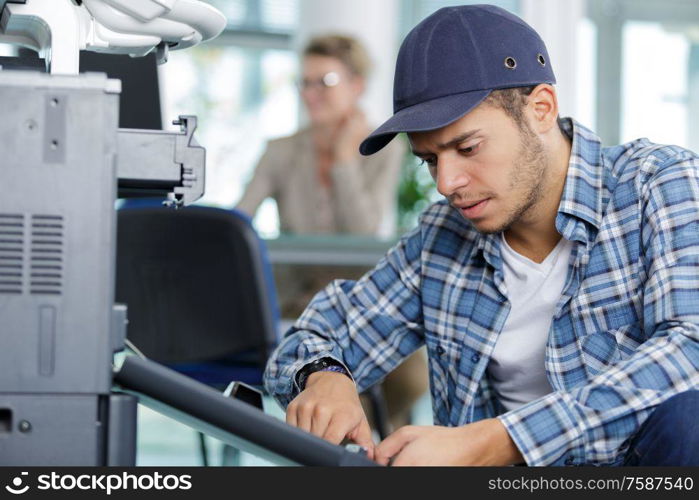 man technician repairing a printer