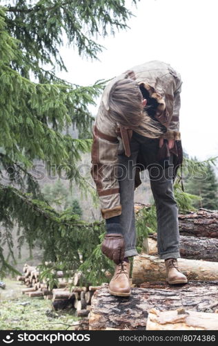 Man tie shoes in the forest