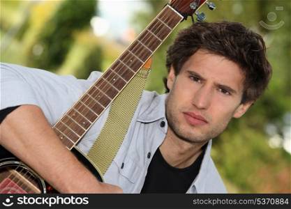 Man tightly holding his guitar