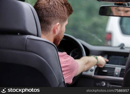 man touching dashboard while sitting in car