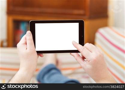 man touching tablet pc with cut out screen in living room