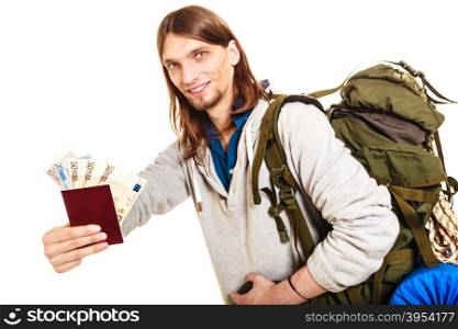 Man tourist backpacker holding money and passport.. Man tourist backpacker holding passport full of money. Young guy hiker backpacking. Summer vacation travel. Studio shot. Isolated on white background.