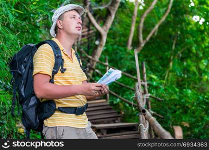 man tourist lost, check with map and terrain in the hike