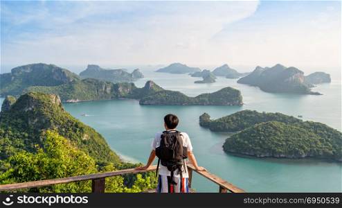 Man tourist on peak island. Man tourist with backpack are looking at the beautiful natural landscape of the sea on peak view point of Ko Wua Ta Lap island in Mu Ko Ang Thong National Park, Surat Thani, Thailand, 16:9 Widescreen