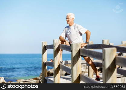 Man training on beach outside. Handsome caucasian male doing exercises on beach