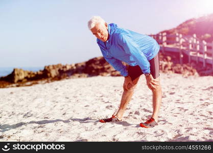 Man training on beach outside. Handsome caucasian male doing exercises on beach