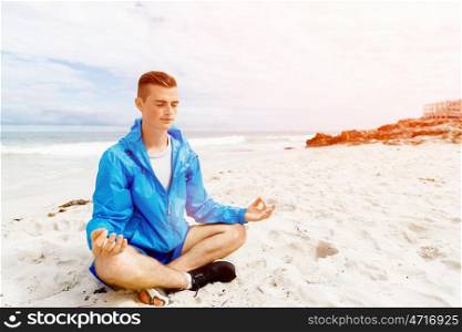 Man training on beach outside. Handsome caucasian male doing exercises on beach