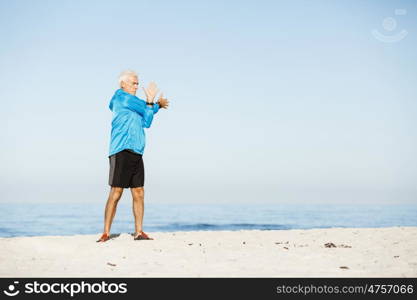 Man training on beach outside. Handsome caucasian male doing exercises on beach