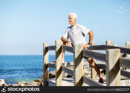 Man training on beach outside. Handsome caucasian male doing exercises on beach