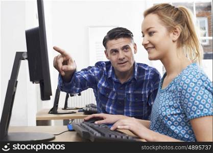 Man Training Woman On Computer In Office