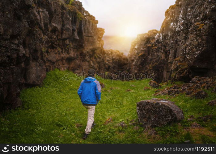 Man traveler and explorer travels in the Icelandic landscape hiking across Iceland to discover unique nature in summer.