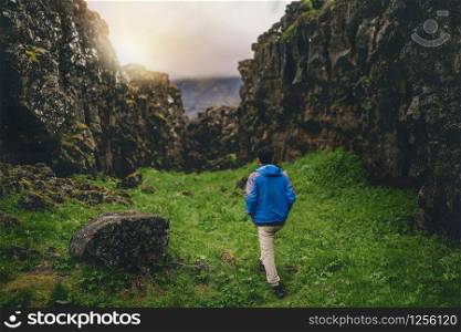Man traveler and explorer travels in the Icelandic landscape hiking across Iceland to discover unique nature in summer.