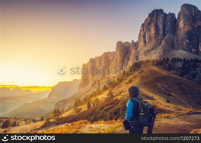 Man traveler hiking alone in breathtaking landscape of Dolomites Mounatins at sunrise in summer in Italy. Travel Lifestyle wanderlust adventure concept. Outdoor wilderness vacations.