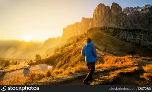 Man traveler hiking alone in breathtaking landscape of Dolomites Mounatins at sunrise in summer in Italy. Travel Lifestyle wanderlust adventure concept. Outdoor wilderness vacations.