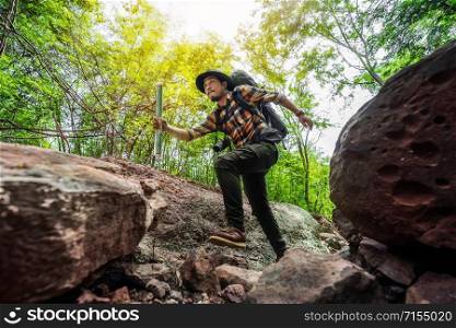 man traveler with backpack running in the natural forest