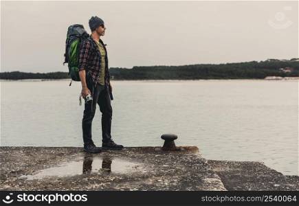 Man Traveling Backpack enjoying the beautiful view of the lake