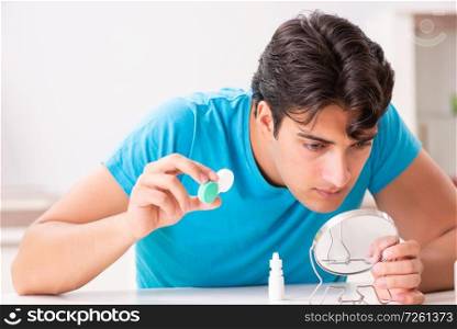 Man trying contact lenses at home