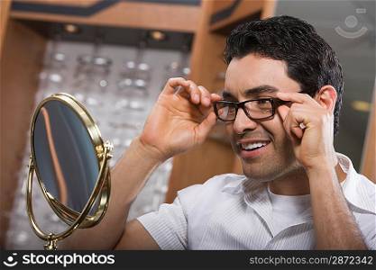 Man trying on eyeglasses in store