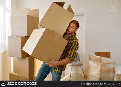 Man trying to keep balance holding stacked cardboard box in hand. Home moving day and relocation. Man trying to keep balance holding box